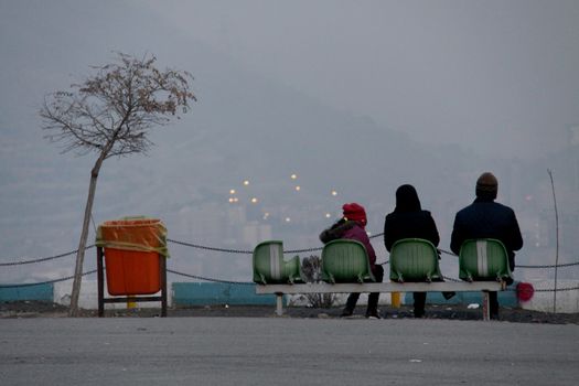 IRAN, Tehran: People sit and look over the skyline of Tehran on December 29, 2015, as thick clouds of pollution hang over the city.The city of an estimated 14 million people was also forced to close schools last week due to the lingering pollution.