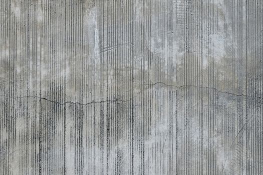 Grey concrete wall with parallel traces from rubbed finish processing abrasive machining and crack check