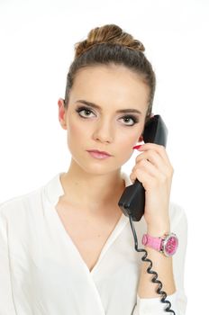 Businesswoman with telephone in her hand. Young female model with elegant office clothes. Kind and serious face expression. 