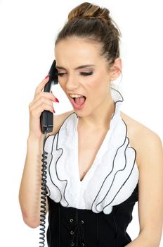 Young office lady screams on phone. Female model holds cable phone in her hand. Angry face expression.