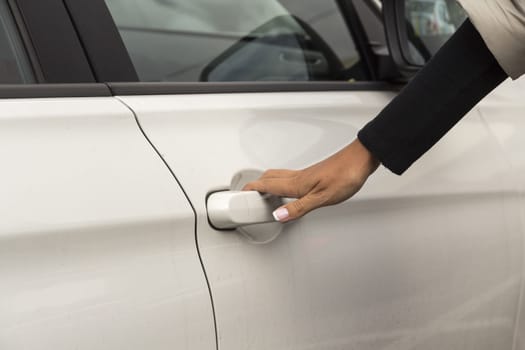 the hand of the girl keeps the handle door white passenger car