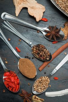 Spices and herbs on black wood background