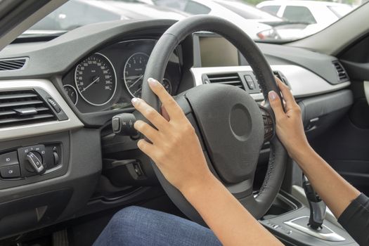 the girl with the manicure keeps hands on the steering wheel of the car