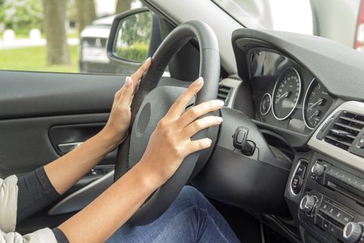 the girl with the manicure keeps hands on the steering wheel of the car