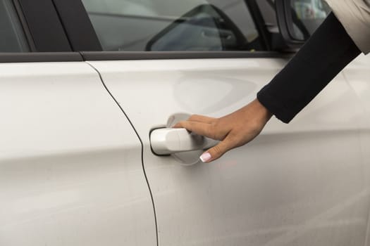 the hand of the girl keeps the handle door white passenger car