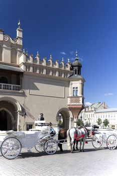 CRACOW, POLAND, July 22, 2013 :  Old-styled horse carriage on main market square next to Cloth Hall. Cracow is the most visited city in Poland by tourists.
