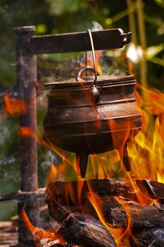 Black Castiron pot over open flame