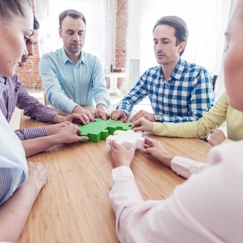 People assembling puzzle, corporate teamwork concept