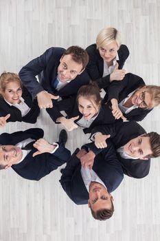Group of business people showing thumbs up signs in joy