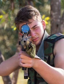 young a soldier in the uniform with weapon