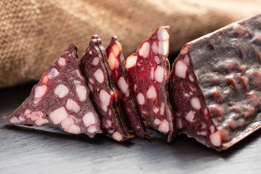 jerked sausage with fat on a dark background
