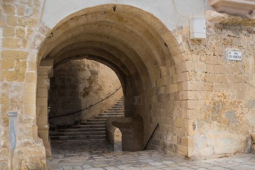 Fortification built in several levels in city Senglea, mediterranean island Malta. Gate - underpass and stairs to the next floor.