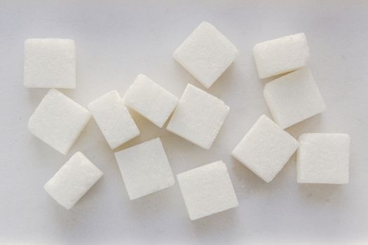 White sugar pieces on a white background.