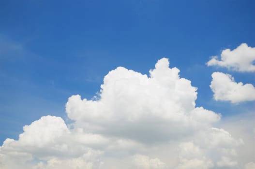 White puffy cumulus cloud on the blue sky as background.