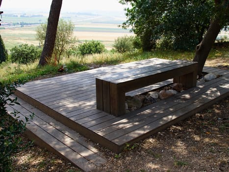 Modern design bench made of wood in a park overlooking beautiful landscape