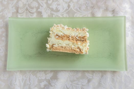 Typical italian meringue pie on rectangular green plate at restaurant,from above.