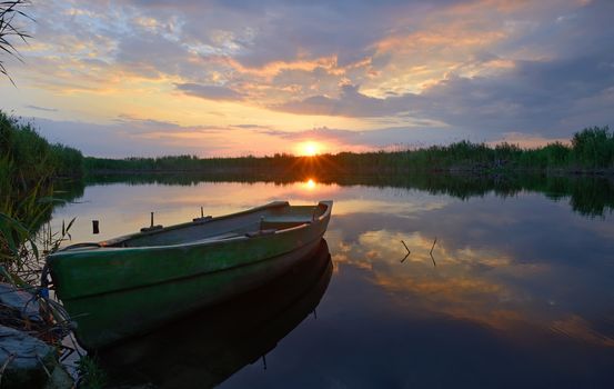 fisherman boat at sunset in summer time