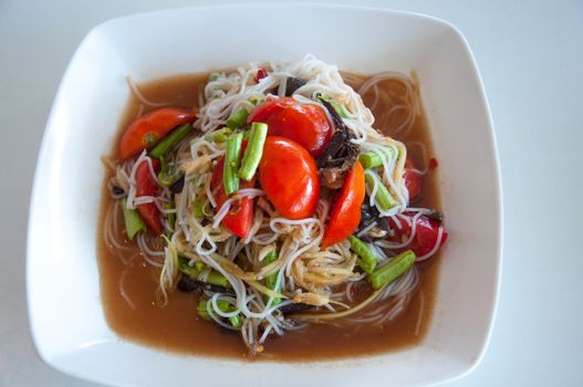 Green papaya salad is a spicy salad made from shredded unripe papaya. It is of Lao origin but it is also eaten throughout Southeast Asia. Locally known in Cambodia as bok l'hong in Laos as tam som or the more specific name tam maak hoong , Lao pronunciation, in Thailand as som tam and in Vietnam as goi du du. Som tam, the Thai variation, was listed at number 46 on World's 50 most delicious foods compiled by CNN Go in 2011