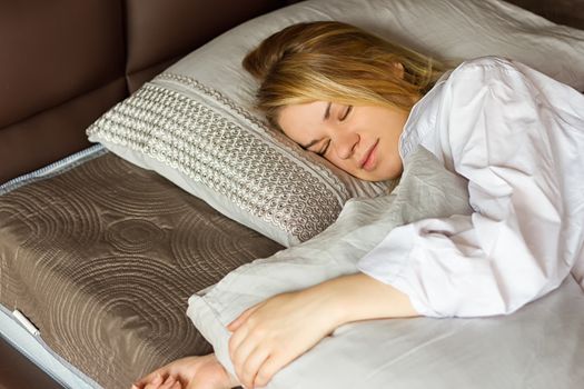 girl in a white men's shirt sleeping on the bed