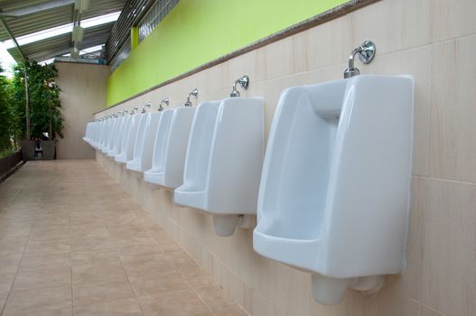 Row white urinals in men's toilet