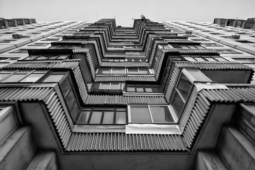 Modern apartment building. Front view. Divercity of windows.