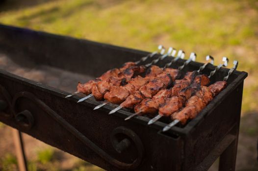 Grilling marinated pork meat on a grill