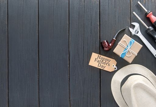 Fathers day gift box tied in blue ribbon over a wooden background with label