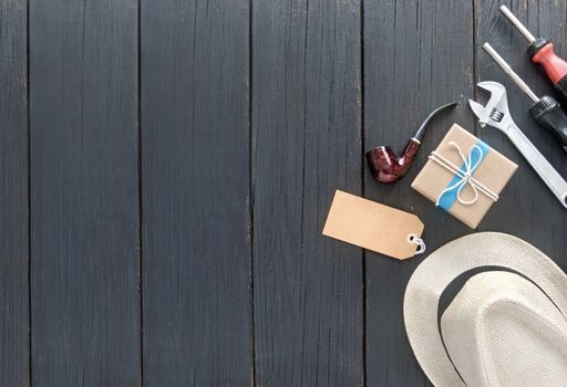 Fathers day gift box tied in blue ribbon over a wooden background with label