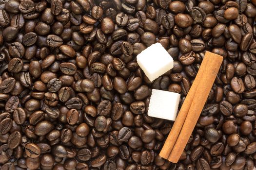 sticks of cinnamon with chunks of white sugar and coffee beans background