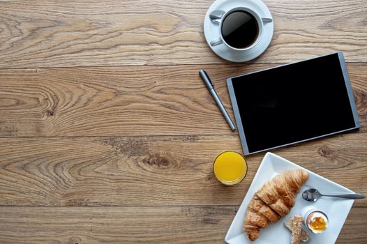 Breakfast with digital tablet on a wooden background with space