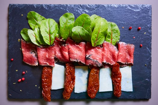 slices of ham with cheese and leaves of beets on the plate