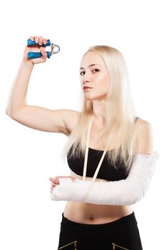 Fitness blond girl with a broken arm in plaster exercising