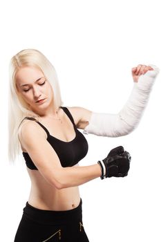 Fitness blond girl with a broken arm in plaster, boxing pose