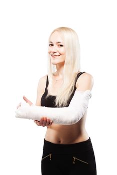 Fitness blond girl with a broken arm in plaster, making thumbs up gesture