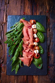 plate of tasty salad with cherry tomatoes, arugula,