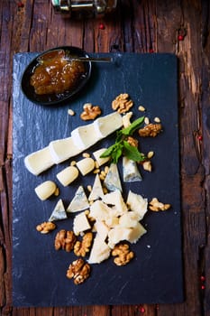 various cheeses on a wooden background top view