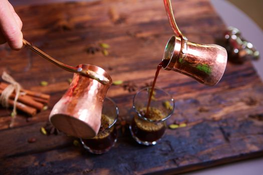 To pour arabic coffee in cups on wooden background. Glass cups