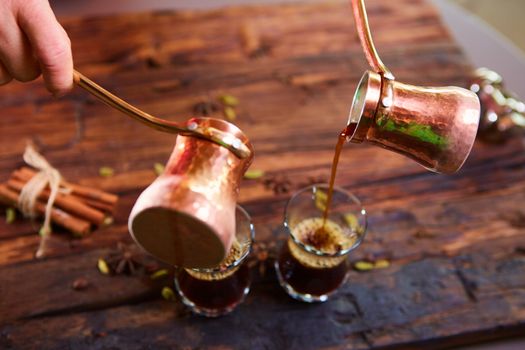 To pour arabic coffee in cups on wooden background. Glass cups