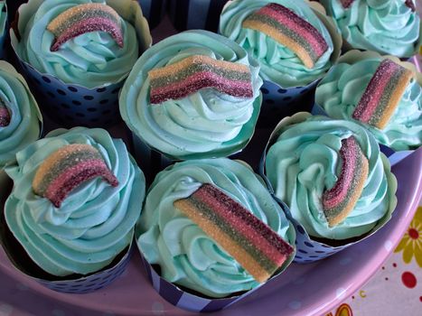 Festive creative Teal birthday cupcake with butter cream icing and colorful decoration