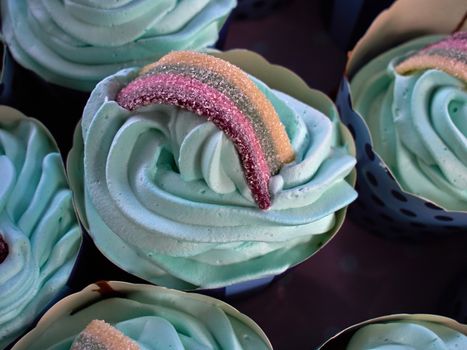 Festive creative Teal birthday cupcake with butter cream icing and colorful decoration