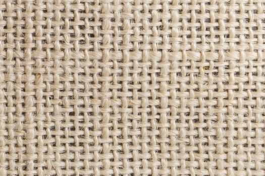Background of close focus on brown fabric made from rough hemp thread. It designed by different size of string cross over in table pattern having small gap.