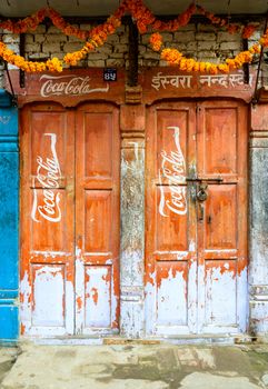 KATHMANDU, NEPAL - CIRCA NOVEMBER 2015: Vintage Coca-Cola advertisement painted on wooden doors.