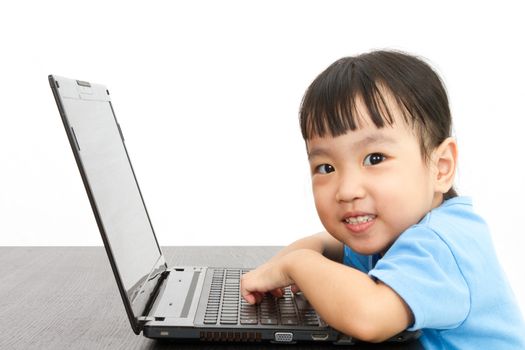 Chinese little girl using laptop in plain isolated white background.