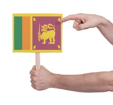 Hand holding small card, isolated on white - Flag of Sri Lanka