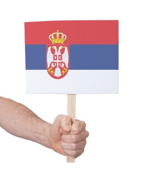 Hand holding small card, isolated on white - Flag of Serbia