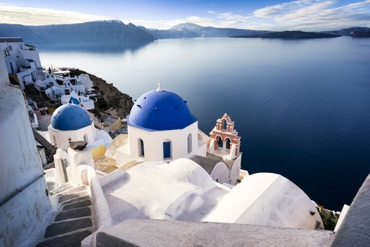 Oia town on Santorini island, Greece. Traditional and famous houses and churches with blue domes over the Caldera, Aegean sea