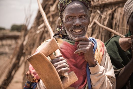 OMORATE, ETHIOPIA - 16 AUGUST 2015:  unidentified old man from Arbore tribe carry in his hands a traditional wooden chair, used also as a neckrest