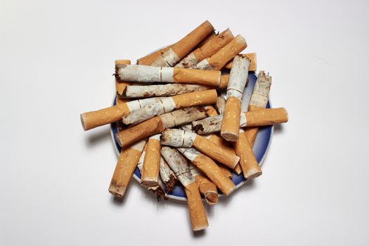 Blue ashtray filled with used cigarette butts isolated on white background