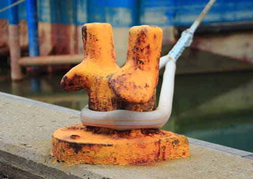 Orange metal pole for mooring of ships at pier