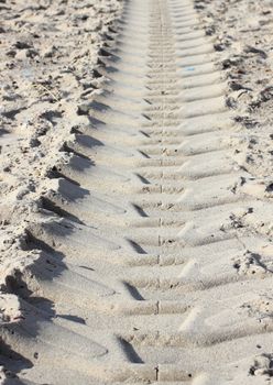 Heavy tractor track in dry beach sand in summer